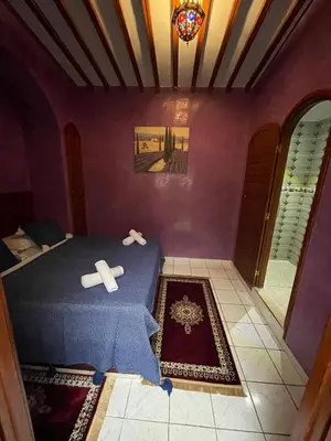 a bedroom with a bed with a blue blanket at Riad Mido in Marrakech