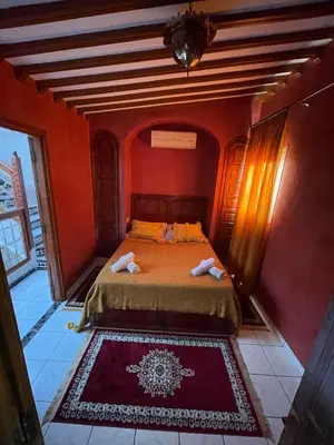 a bedroom with a bed in a red room at Riad Mido in Marrakech