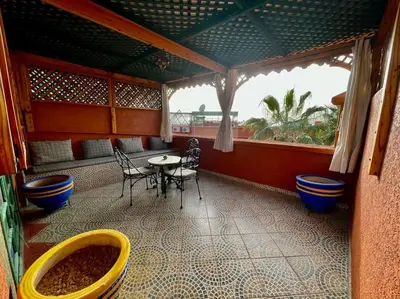 a room with a table and chairs and a window at Riad Mido in Marrakech