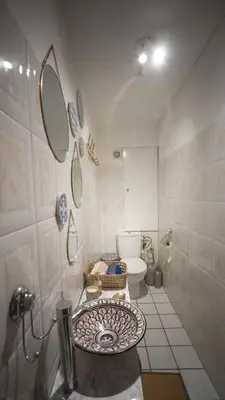 a bathroom with a toilet and two mirrors on the wall at Riad kechin in Marrakech