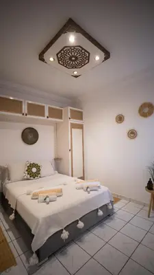 a bedroom with a large bed with a ceiling at Riad kechin in Marrakech