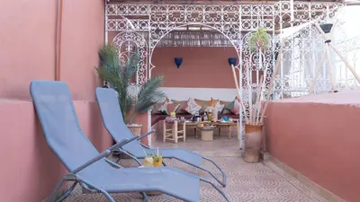 a blue chair sitting on a balcony with a table at Riad kechin in Marrakech