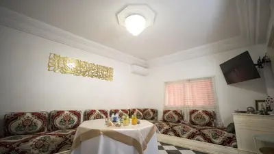 a living room with a table and a couch at Riad kechin in Marrakech