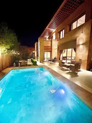 a large blue swimming pool in front of a building at Villa à marrakech avec piscine in Marrakech