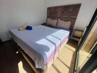a bedroom with a large bed with a wooden headboard at Appartement bien équipé in Marrakech