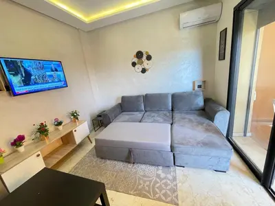 a living room with a couch and a table at Appartement bien équipé in Marrakech
