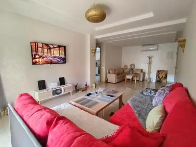 a living room with a red couch and a table at Marrakech Luxury ATLAS in Marrakech