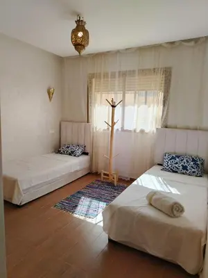 two beds in a room with a cross on the wall at Marrakech Luxury ATLAS in Marrakech