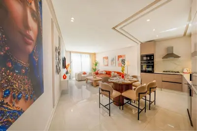 a living room with a table and chairs and a kitchen at Luxe Urbain - 3 Chambres en Centre-Ville in Marrakech