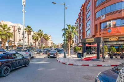 a busy city street with cars parked in front of a building at Luxe Urbain - 3 Chambres en Centre-Ville in Marrakech