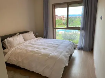 a bedroom with a white bed and a window at Prestigia Aparts de Vacances by Sabor Voyage in Marrakech