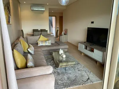a living room with a couch and a television at Prestigia Aparts de Vacances by Sabor Voyage in Marrakech