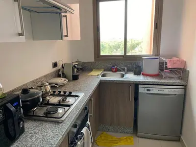 a kitchen with a stove top oven next to a sink at Prestigia Aparts de Vacances by Sabor Voyage in Marrakech