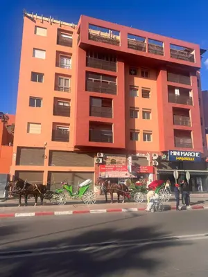 a tall orange building with horses in front of it at Un rêve à Marrakech in Marrakech