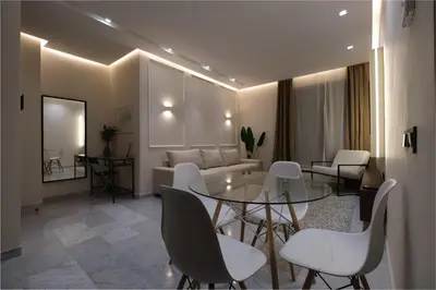a living room with a glass table and white chairs at Stylish and Central Downtown Retreat in Marrakech