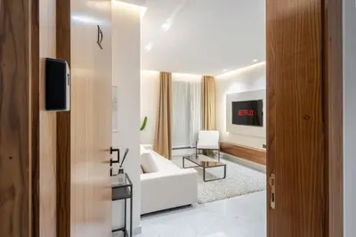 a living room with a white couch and a tv at Stylish and Central Downtown Retreat in Marrakech