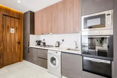 a kitchen with a washing machine and a microwave at Stylish and Central Downtown Retreat in Marrakech
