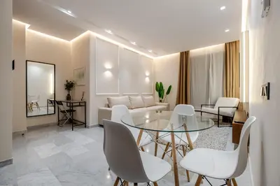 a living room with a glass table and white chairs at Stylish and Central Downtown Retreat in Marrakech