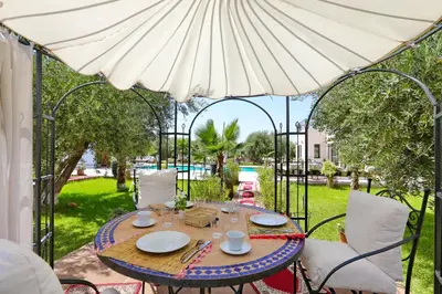 a table and chairs under an umbrella on a patio at Villa Sahar in Marrakech