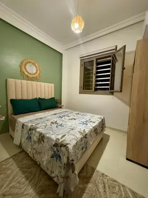 a bedroom with a bed in a room with a window at Marrakech Airport Appart in Marrakech
