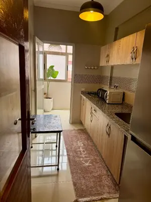 a kitchen with a counter and a table in it at Marrakech Airport Appart in Marrakech
