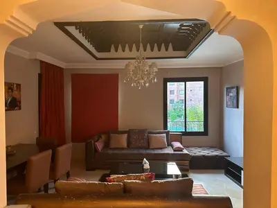 a living room with a couch and a chandelier at Appartement meublé à River palm in Marrakech