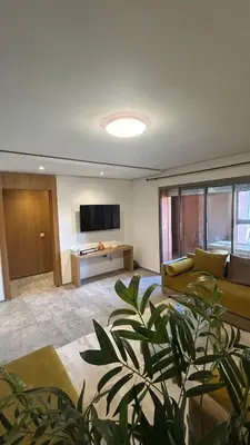 a living room with a couch and a television at Center appartement Marrakech in Marrakech