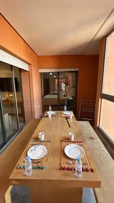 a wooden table with two white plates on it at Center appartement Marrakech in Marrakech