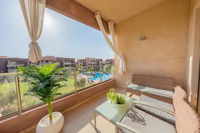 a balcony with tables and chairs and a large window at Exceptional Golf Apartment - 2 Bedrooms Prestigia Marrakech in Marrakech