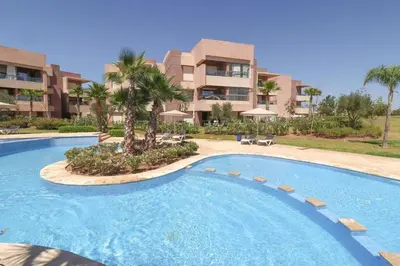 a large swimming pool in front of a building at Exceptional Golf Apartment - 2 Bedrooms Prestigia Marrakech in Marrakech