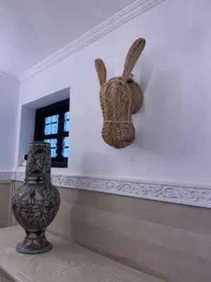 a statue of a rabbit on a wall next to a vase at Riad BAB 19 in Marrakech