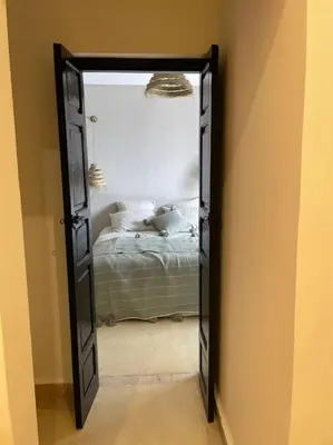 a mirror in a room with a bed in a bedroom at Riad BAB 19 in Marrakech