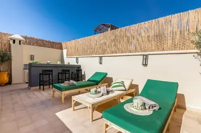 a patio with green furniture and a fireplace at Riad BAB 19 in Marrakech