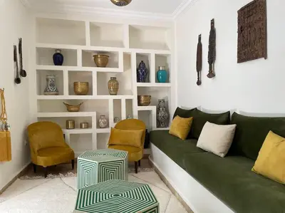 a living room with a green couch and chairs at Riad BAB 19 in Marrakech