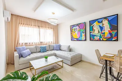 a living room with a couch and a painting on the wall at Gueliz Harmony - Salon et Suites Marrakech in Marrakech