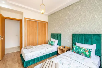 two beds in a room with green accents at Gueliz Harmony - Salon et Suites Marrakech in Marrakech