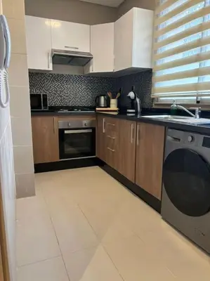 a kitchen with a sink and a dishwasher at Jubaea youmna in Marrakech