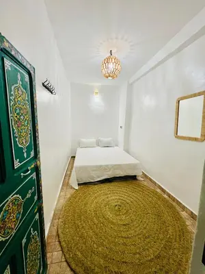 a small bedroom with a bed and a large rug at Maison Cascada 2 in Marrakech