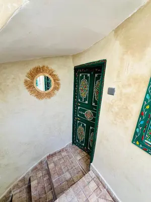 a hallway with a green door and a mirror at Maison Cascada 2 in Marrakech