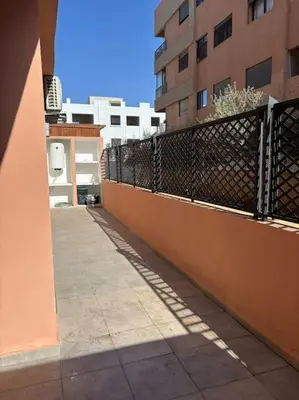 an empty sidewalk next to a building with a fence at Luxury apartment in Marrakech in Marrakech