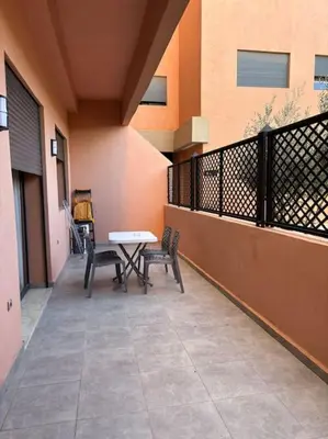 a patio with two chairs and a table on a balcony at Luxury apartment in Marrakech in Marrakech