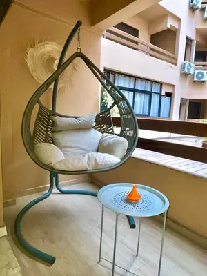 a swing chair and a table on a balcony at Chic appartement marrakech in Marrakech
