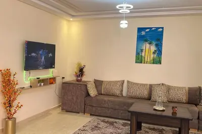 a living room with a couch and a flat screen tv at Apparemment de haut standing in Marrakech