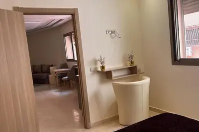 a bathroom with a mirror and a living room at Apparemment de haut standing in Marrakech
