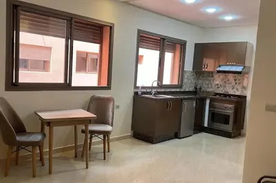 a kitchen with a table and a table and chairs at Apparemment de haut standing in Marrakech