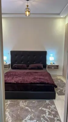 a bedroom with a large bed with a black headboard at Apparemment de haut standing in Marrakech