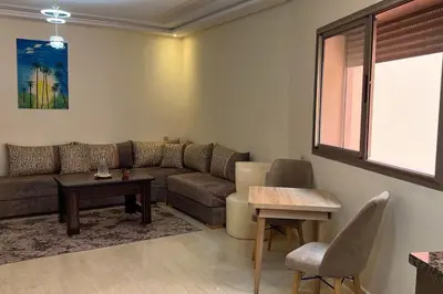 a living room with a couch and a table at Apparemment de haut standing in Marrakech