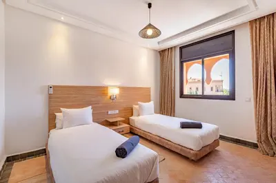a hotel room with two beds and a window at Villa Riad Targa 10 min de GUELIZ Piscine privee in Marrakech