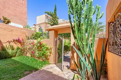 a garden with a gate and a cactus at Villa Riad Targa 10 min de GUELIZ Piscine privee in Marrakech