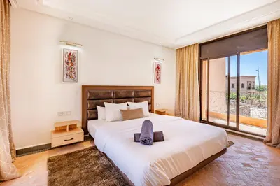 a bedroom with a large bed and a large window at Villa Riad Targa 10 min de GUELIZ Piscine privee in Marrakech